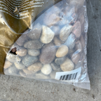 Bag of stones with a visible brand name on a concrete surface