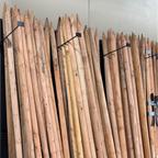 Row of wooden stakes with metal bands on a white wall