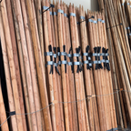 Bamboo sticks with black bands and labels on a metal rack.