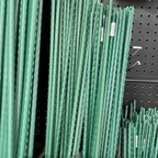 Green metal stakes on a black pegboard