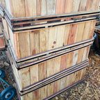 Stack of wooden crates with metal straps on a ground surface