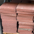 Stacks of red bricks on a wooden pallet in an indoor setting